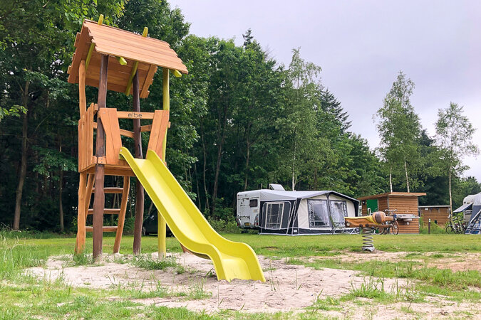 Spielgeräte für Campinganlagen – Ein Campingplatz mit einer Rutsche von eibe im Vordergrund.