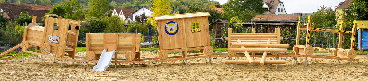 Kindergarten-Spielgeräte von eibe – Spielanlage in Form einer Holzeisenbahn auf einem Kindergarten-Gelände.